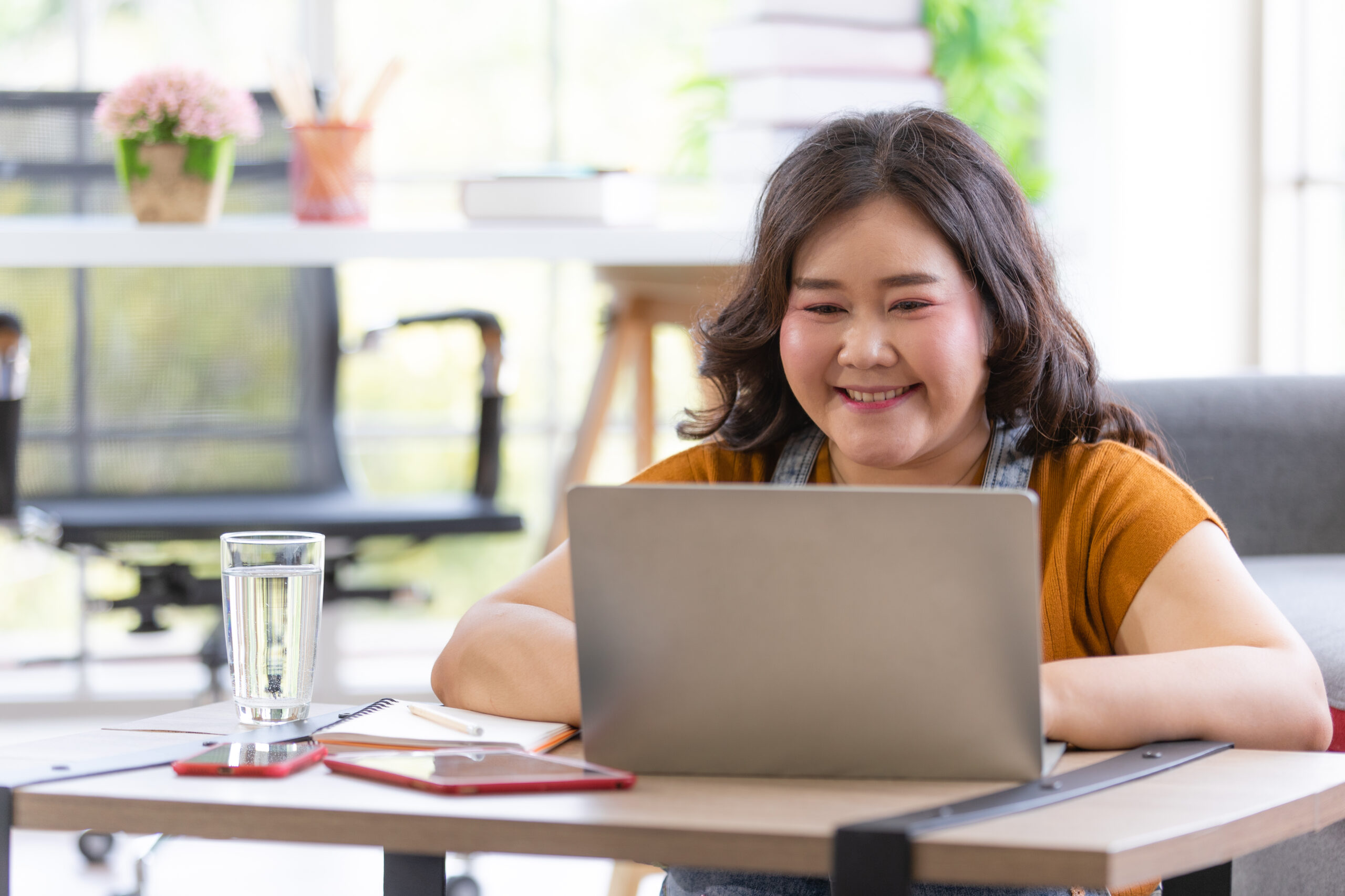 portrait of happy fat individual smiling and sitting at laptop