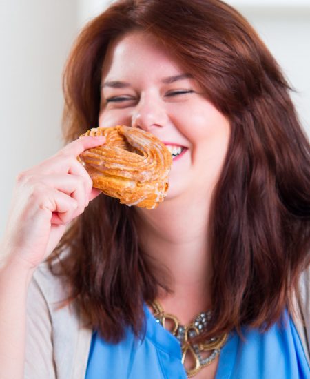 woman joyfully eating a donut